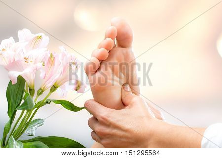 Macro close up of hands applying pressure on female foot.