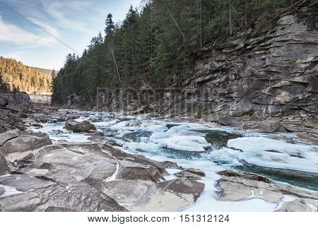 Winter mountain landscape with river and forest Prut river in Carpathians Ukraine
