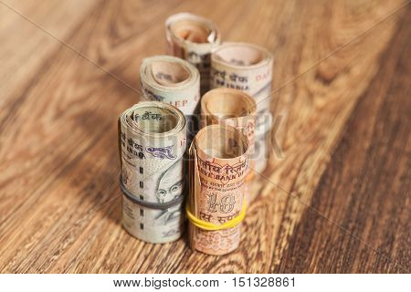 Rolls of Indian rupees on wooden background