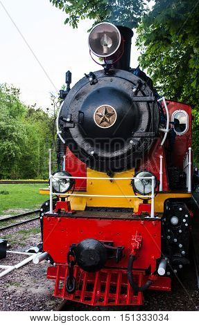 Steam locomotive with the smoke blowing off out of the smokestack.