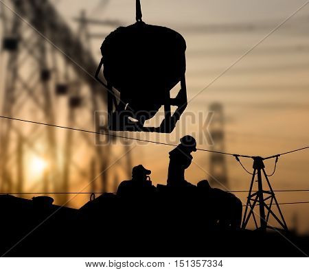 Silhouette working men construction in a building site over Blurred substation