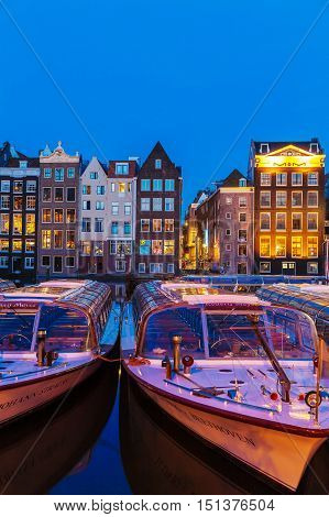 Amsterdam, Netherlands - April 3, 2008: Tour Boats And Dancing Houses Along The Damrak Canal