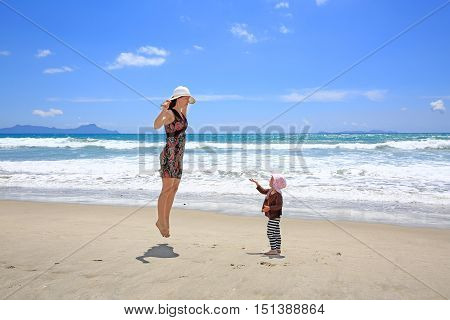 Young Pretty Woman With Little Daughter Having Fun On Sandy Beach