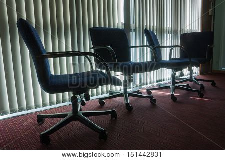 Silhouette Styled Of Four Empty Chairs In Office With Blind Background