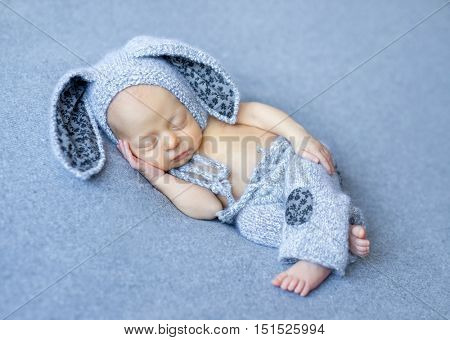 lovely newborn boy in blue hare suit with long ears