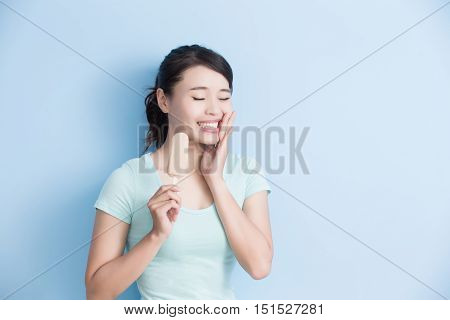 woman have sensitive teeth with ice isolatd on blue background asian