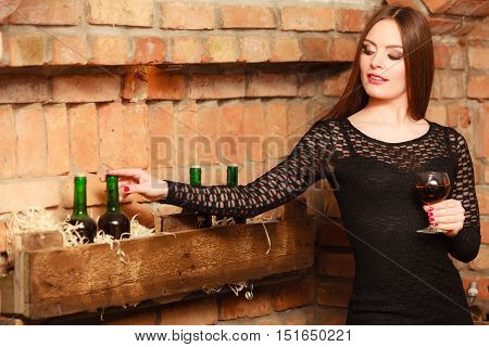 Woman Tasting Wine In Rural Cottage Interior
