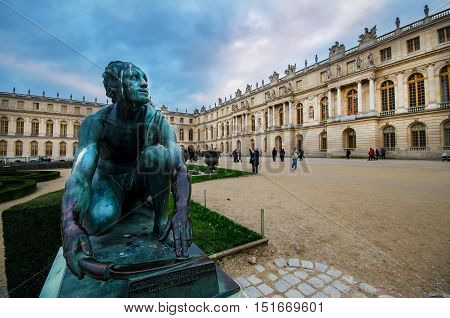 VERSAILLES PARIS FRANCE - DECEMBER 6 ;Visitors in garden Palace Versailles with statue and pond on December 6 2014 at the Palais of Versailles near Paris France.