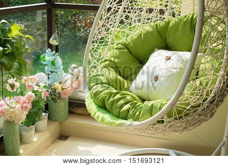 garden swing with mattress and cushion in a balcony in the morning