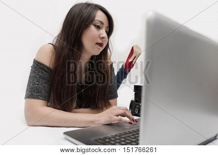 Young beautiful girl lying in front of computer
