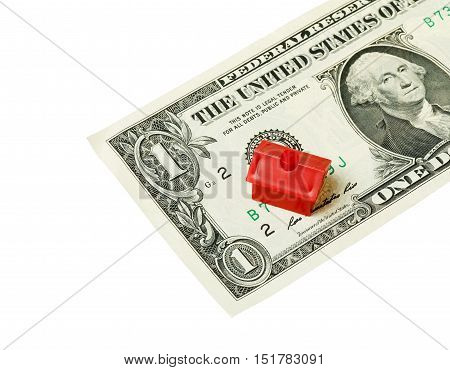 Litle plastic red house on a one US dollar banknote isolated on white background.