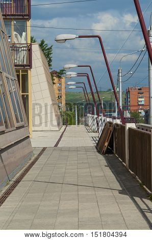The building terrace going to a distance with street lamps