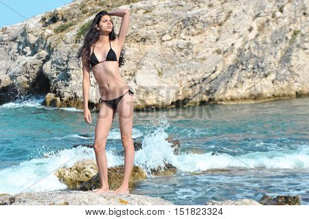 beautiful young skinny model posing on nature with black bikini