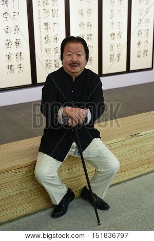 Saint-Petersburg Russia - September 12 2016: The richest Chinese artist Cui Ruzhuo to the opening of his exhibition in the Central Exhibition Hall on the background of his paintings.