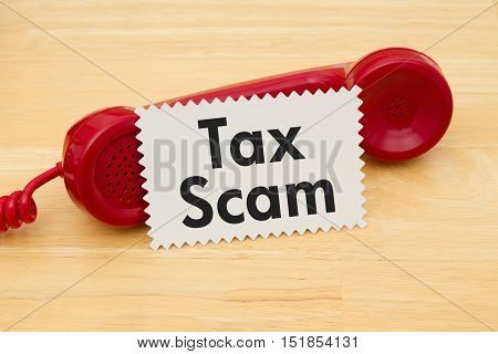 Getting a call that is an Tax Scam A retro red phone with note card on a desk with text Tax Scam