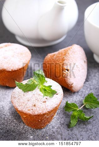 Sponge cakes with raisins decorated with powdered sugar and mint leaves