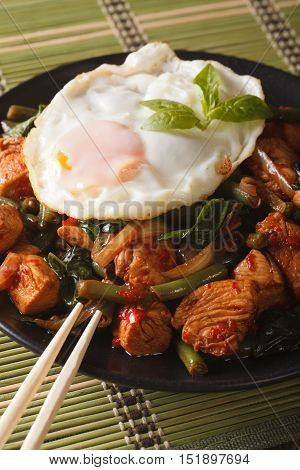 Thai Chicken With Basil And Egg Close-up On A Plate Vertical