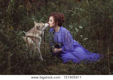 Dog tongue licking the girl's face they are in the fairy forest.