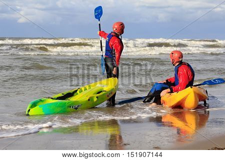 Kijkduin beach the Netherlands - October 14 2012: man and woman with sit on top kayaks