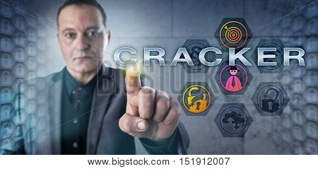 Experienced security expert with kind yet determined facial expression pressing CRACKER onscreen. Information technology concept and computer security metaphor for a person breaking into computers.