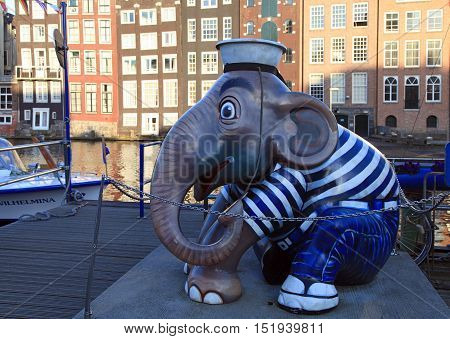 AMSTERDAM, THE NETHERLANDS - MAY 03, 2016: Sculpture of elephant sailor at pier of canal on Damrak street in city center, Amsterdam, Netherlands. Selective focus