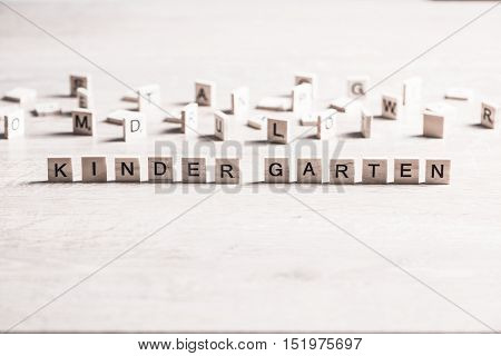 Alphabet letters on wooden pieces collected to word kinder garten