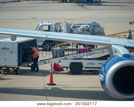 San Francisco, Ca July 3, 2018: Jetblue Baggage Handler Loading Luggage Into An Airliner At Reagan I