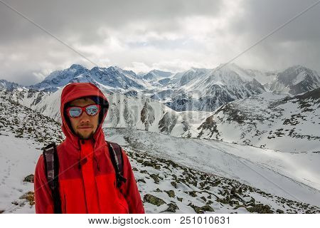 Selfi Male Mountaineer In Snowy Mountains, Wearing A Helmet With A Backpack.