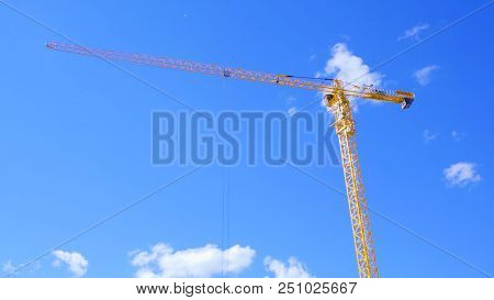 Machinery Crane Construction, Tool Of Building Industry. Yellow Construction Crane On Blue Sky Backg