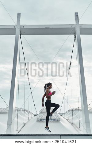 Cardiovascular Exercise. Full Length Of Modern Young Woman In Sports Clothing Jumping While Exercisi