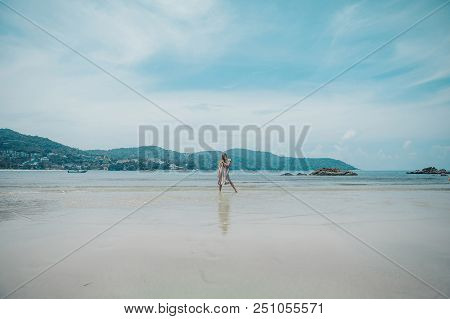Handsome Girl On The Beach Background. Portrait Of A Woman In White Clothes On The Sea