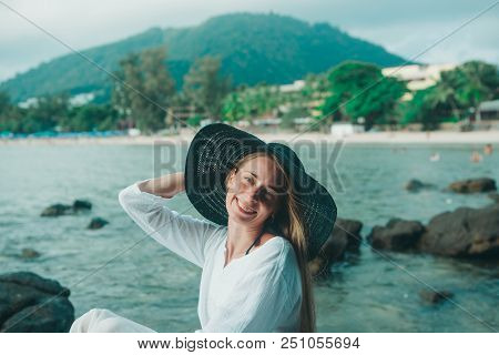 Handsome Girl In Hat On The Beach Background. Portrait Of A Woman In White Clothes And Balck Hat On 
