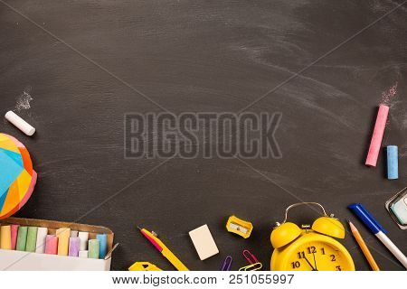 Bright Office Supplies, Yellow Alarm Clock On Black Chalkboard Top View, Copy Space. Concept: Back T