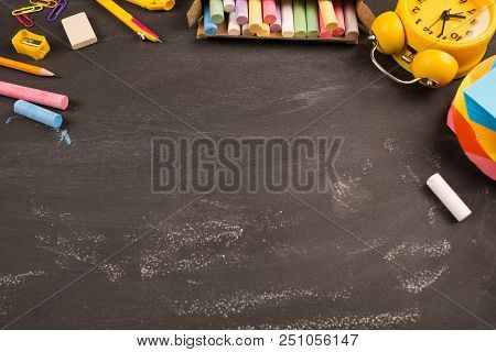 Bright Office Supplies, Yellow Alarm Clock On Black Chalkboard Top View, Copy Space. Concept: Back T