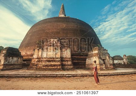 Ancient City Polonnaruwa And Woman Walking Past Sacred Stupa Rankoth Vehera. Buddhist Structure Of 1