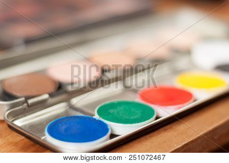 Blurry Professional Cosmetic Background. Cream Concealer Pallet And Aqua Make Up. Working With Skin 