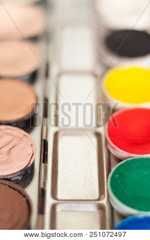 Blurry Professional Cosmetic Background. Cream Concealer Pallet And Aqua Make Up. Working With Skin 