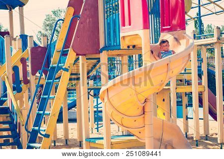 Children Ride On A Children's Roller Coaster In The Park.