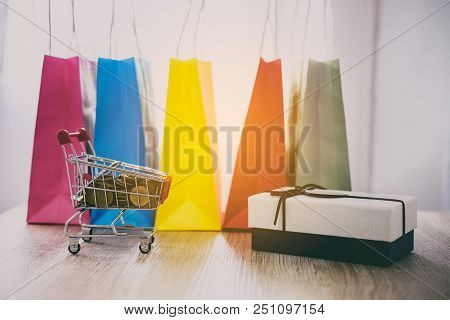 Model Of Shopping Cart On Wooden Floor And Gift Box And Shopping Bag, Online Payment And Shopping Co