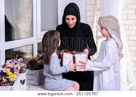 Arabic Mother Giving Gift To Her Boy And Girl.muslim Family.