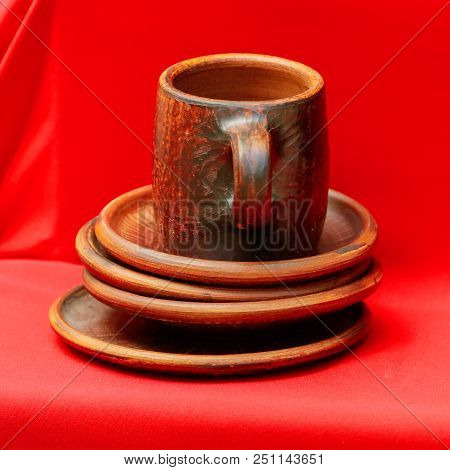 Tableware From Clay On A Red Tablecloth .