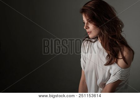 A Beautiful Brunette Girl With Her Hair Down In A White Tunic Stands In A Half-turn.the Photo Can Be