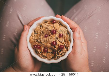 Woman Holding Bowl Of Tasty Cereal Corn Flakes With Red Currant Berries From Above Healthy Delecious
