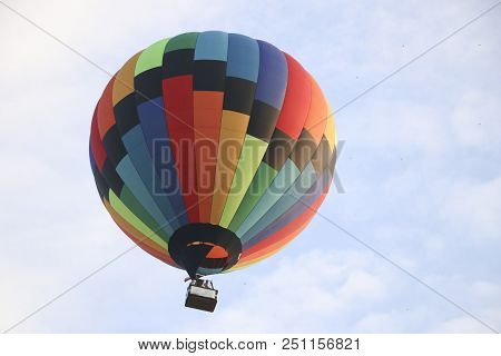 Colorful Hot Air Balloon Against Blue Sky. Hot Air Balloon Is Flying In White Clouds. Beautiful Flyi