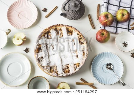 Homemade Apple Pie Sprinkled With Powdered Sugar In Female Hand On A White Table Next To Apples, Cin