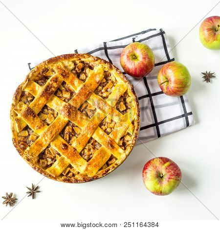 Traditional American apple pie with dough decoration in a grid on a white table. Autumn baking conce