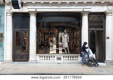 London, Uk - July 9, 2016: Shopper Walks By Bottega Veneta Fashion Shop At Old Bond Street In London
