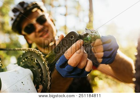 Close Up Shot Of Concentrated And Smiling Young Rider In Helmet, Glasses And Gloves Sitting In Front