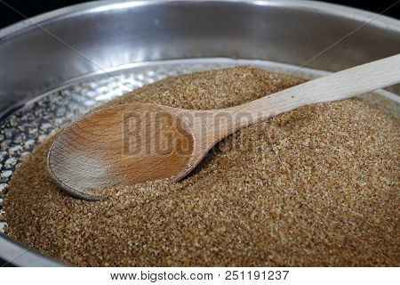 A Wooden Spoon And A Thin Brown Bulgur In A Bowl