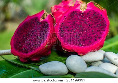 Fresh Red Dragon Fruit On Green Leaf With Stones